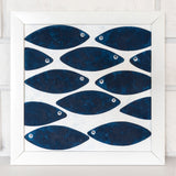 Blue Fish wall art shown front-facing in a white frame against a light neutral wall
