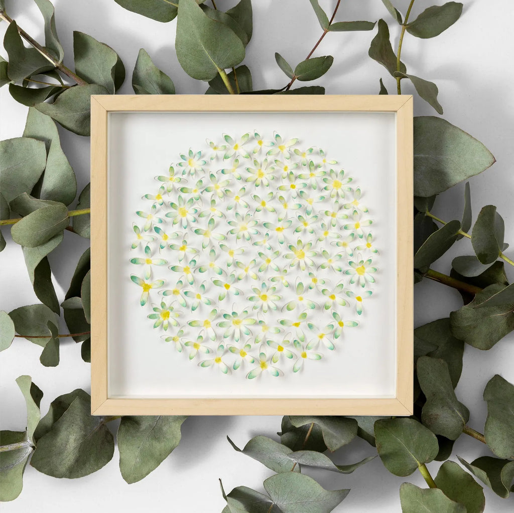 Framed 3D daisy wall art styled with eucalyptus leaves around the frame
