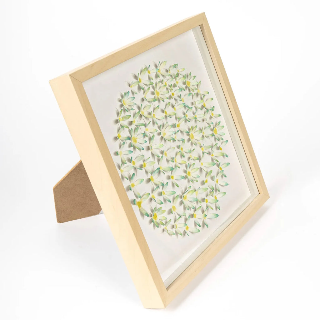 Angled view of framed 3D daisy artwork showing depth and layered flowers

