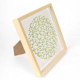 Angled view of framed 3D daisy artwork showing depth and layered flowers
