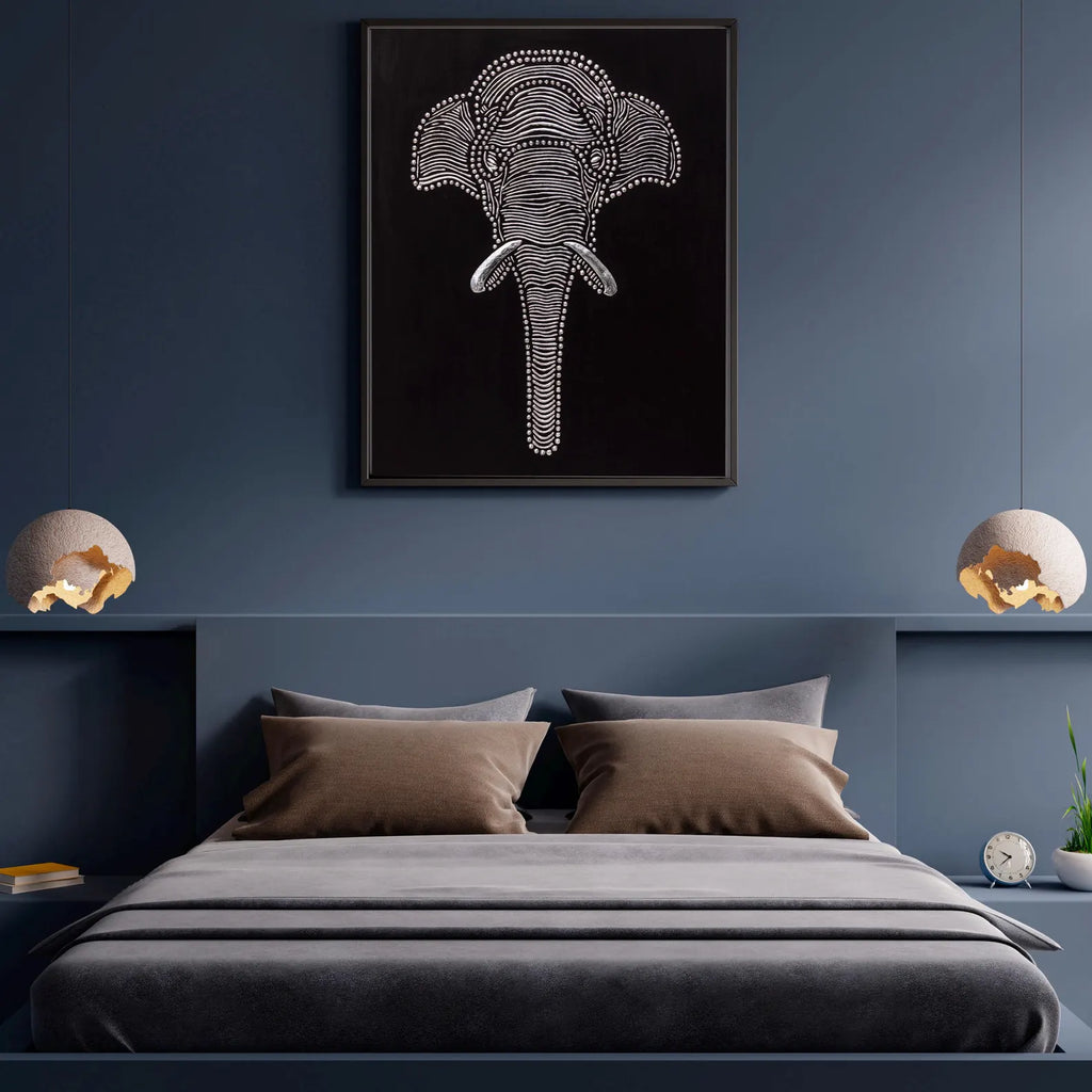 Textured elephant wall art styled above a bed in a dark modern bedroom