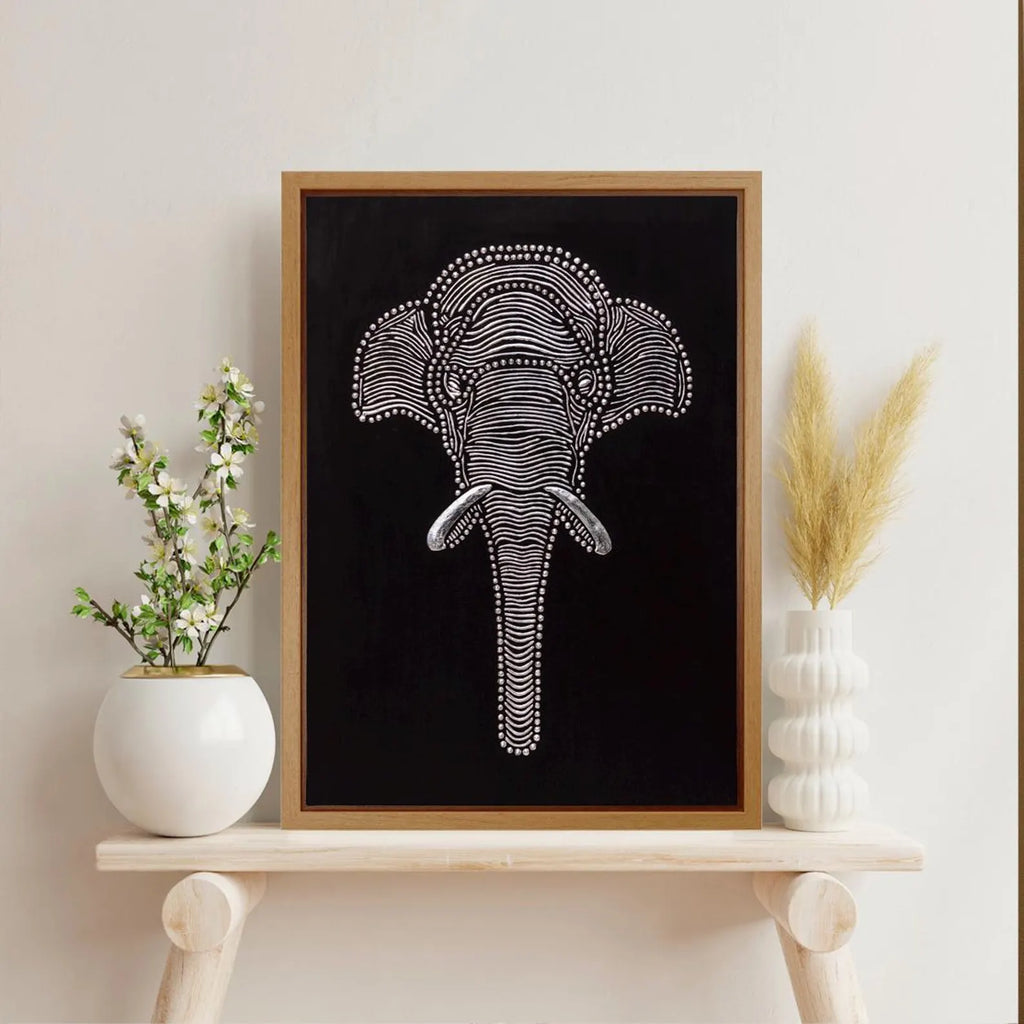 Elephant relief wall art styled on a light shelf with decorative vases