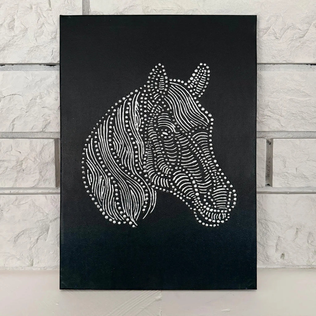 Horse relief canvas artwork displayed on a wall with a black background