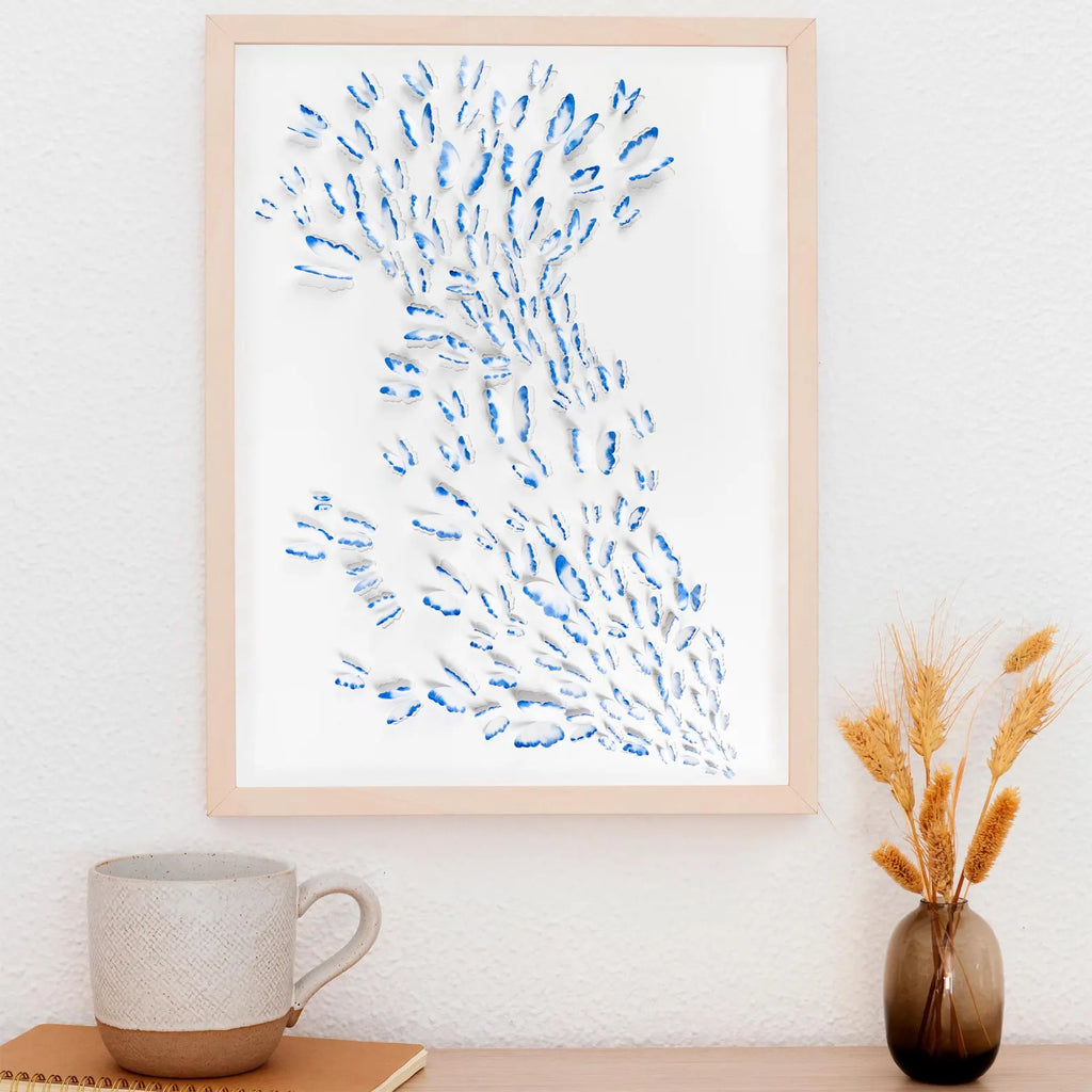 Blue Butterfly Wall Art in natural wood frame styled above a desk with soft neutral decor
