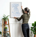 Scale view of Blue Butterfly Wall Art being placed on a wall in a bright interior