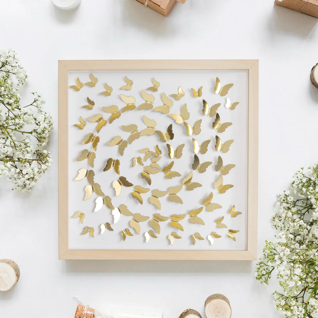 Gold Butterfly Spiral Wall Art photographed in a floral flat lay composition