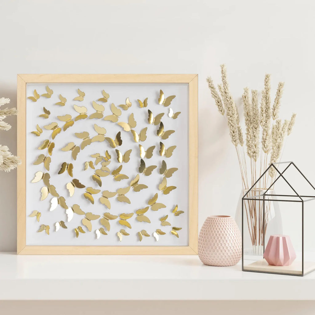 Gold Butterfly Spiral Wall Art displayed on a shelf with soft neutral decor
