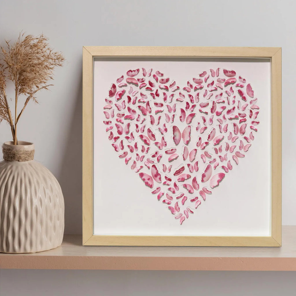 Pink Butterfly Heart Wall Art displayed on a shelf with a textured ceramic vas