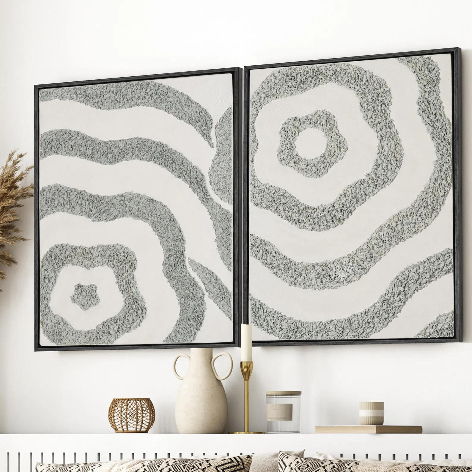 Close interior styling of two framed textured abstract canvas artworks with black frames and neutral decor