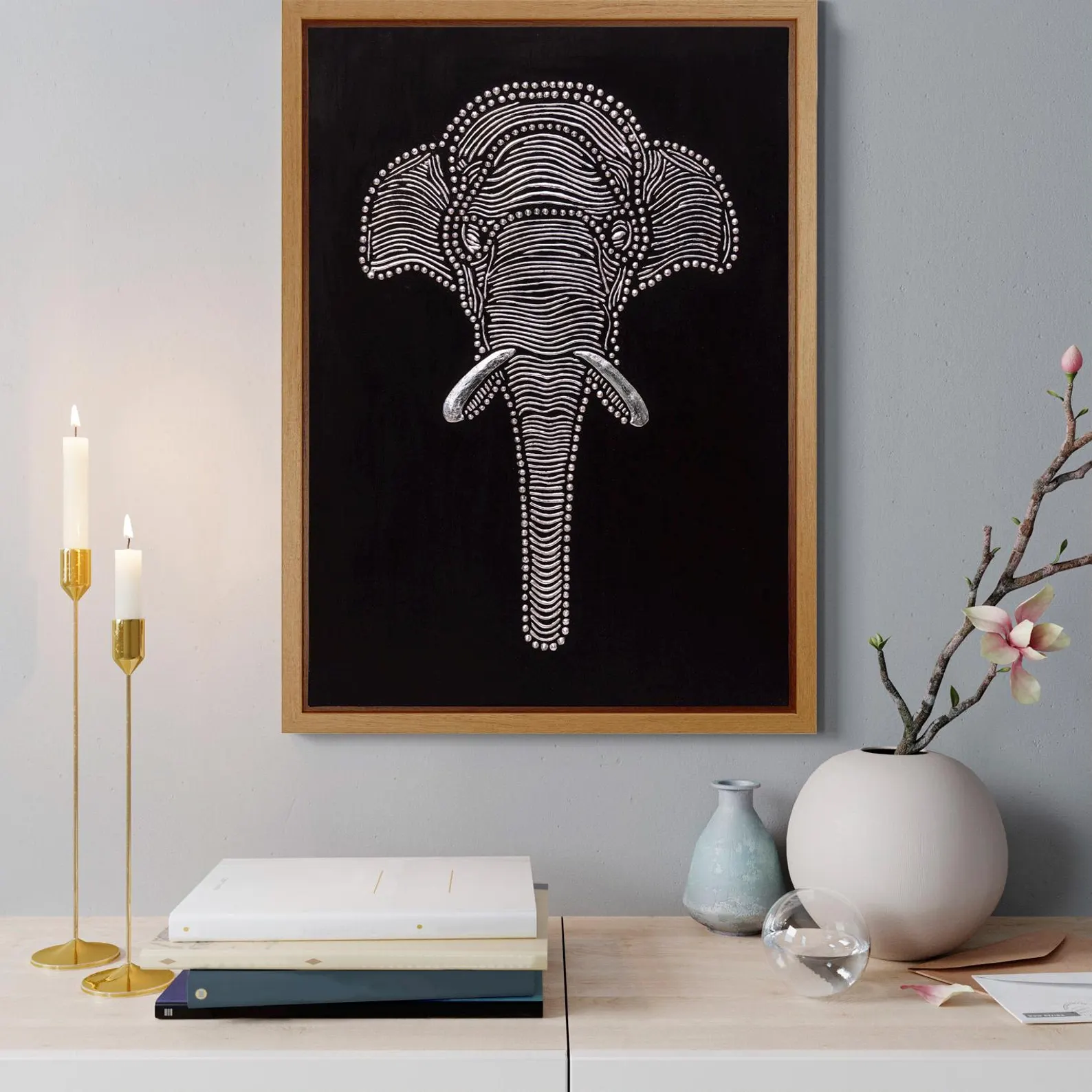 Handmade textured elephant wall art styled above a console table with candles, books and soft neutral decor.