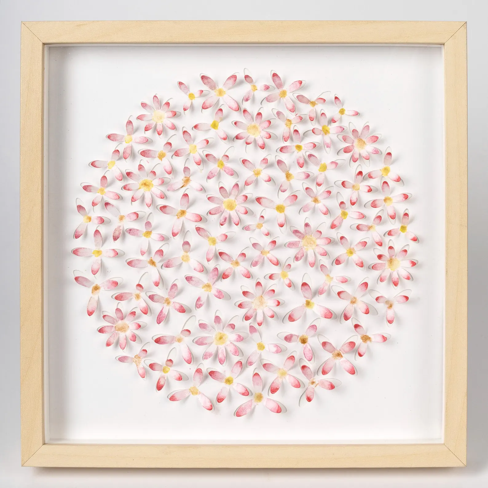 Front view of pink daisy circle 3D watercolor wall art in a light wood shadow box frame